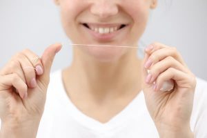 mujer usando hilo dental